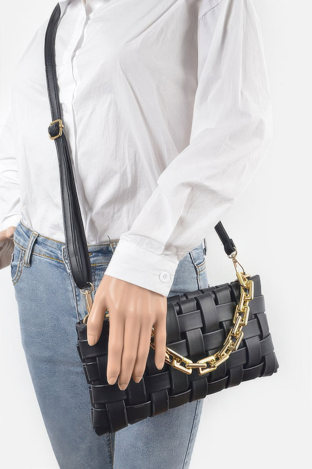 Black braided chain crossbody bag with gold chain strap, worn at the side