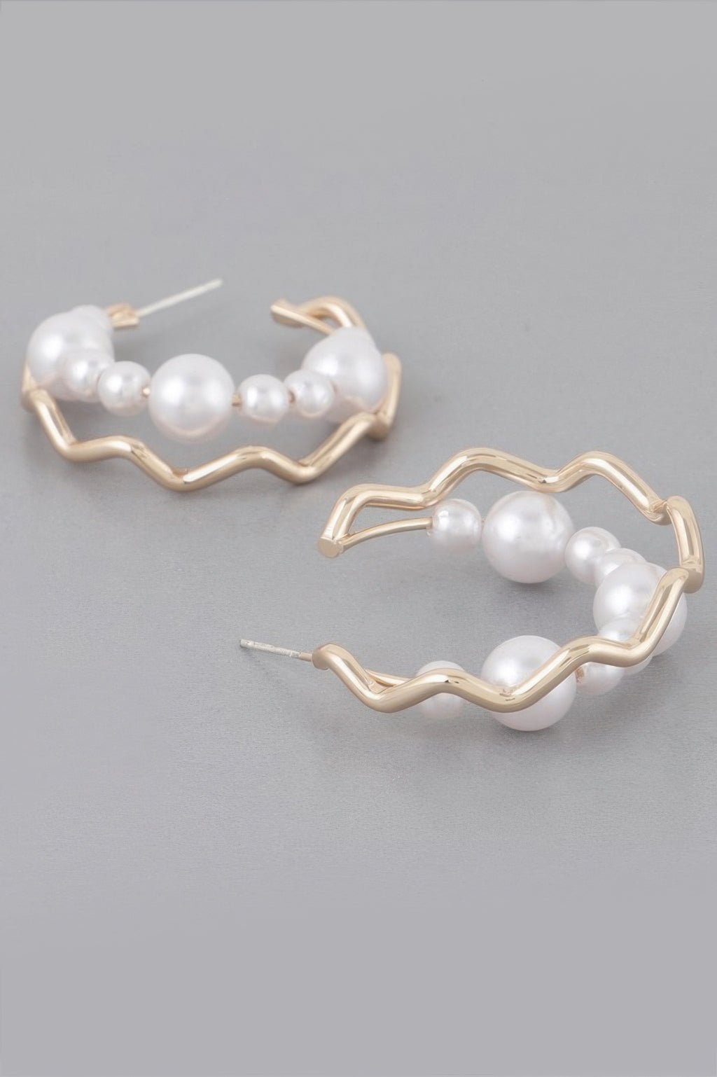 Close view of gold-cream zigzag faux pearl hoops with white faux pearls