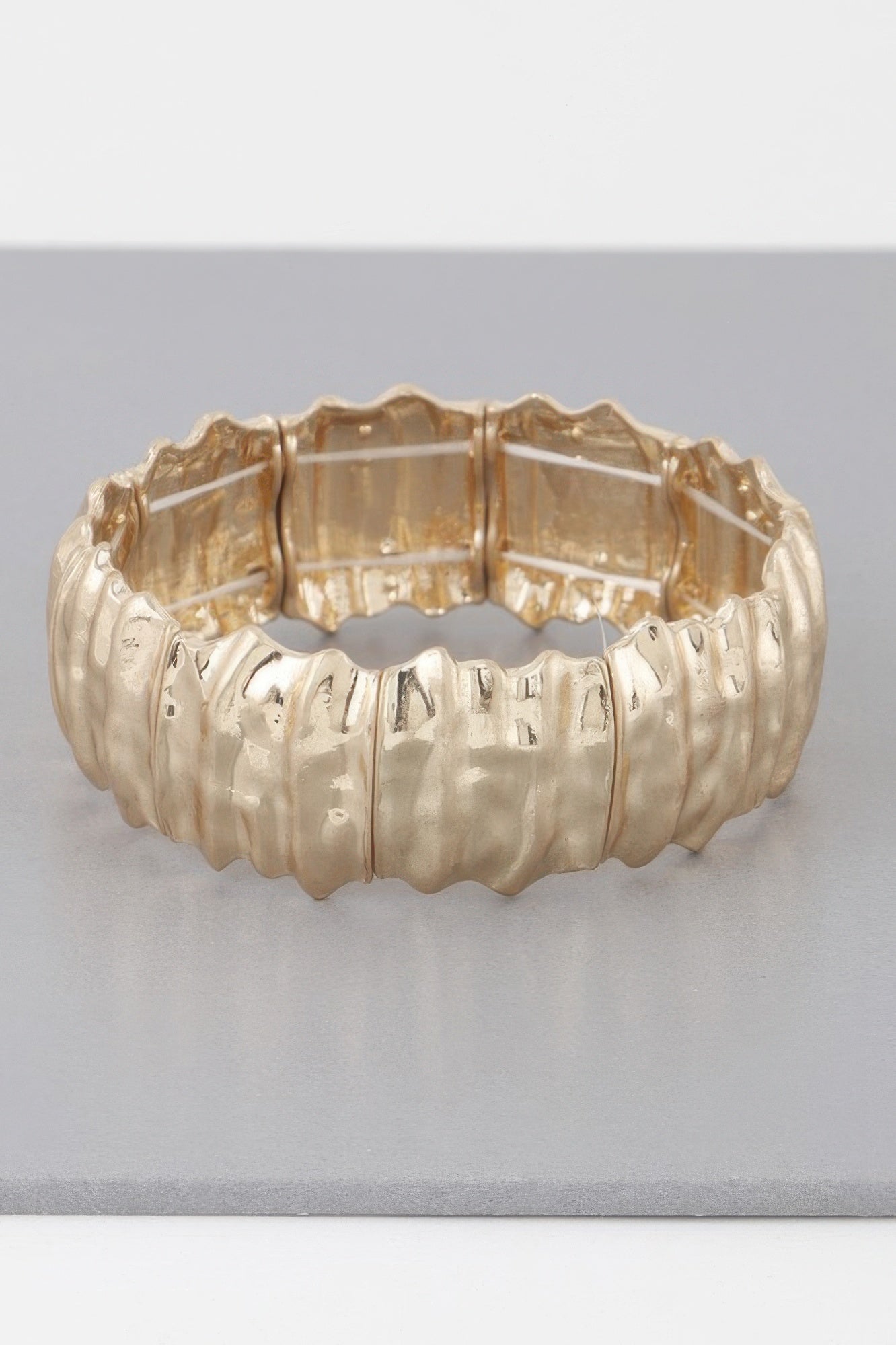 Hammered metal bracelet bangle with ridged texture and hinged interior, gold-tone