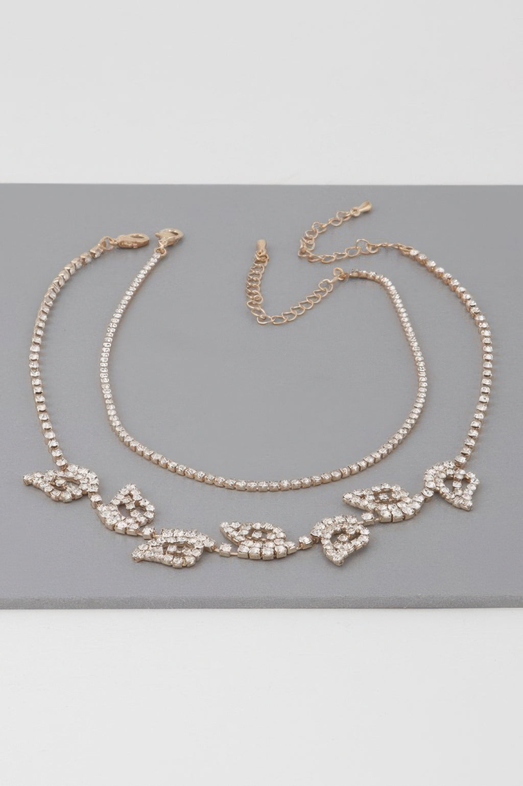 Gold clear rhinestone leaf choker necklace laid flat with clasp and linked chain