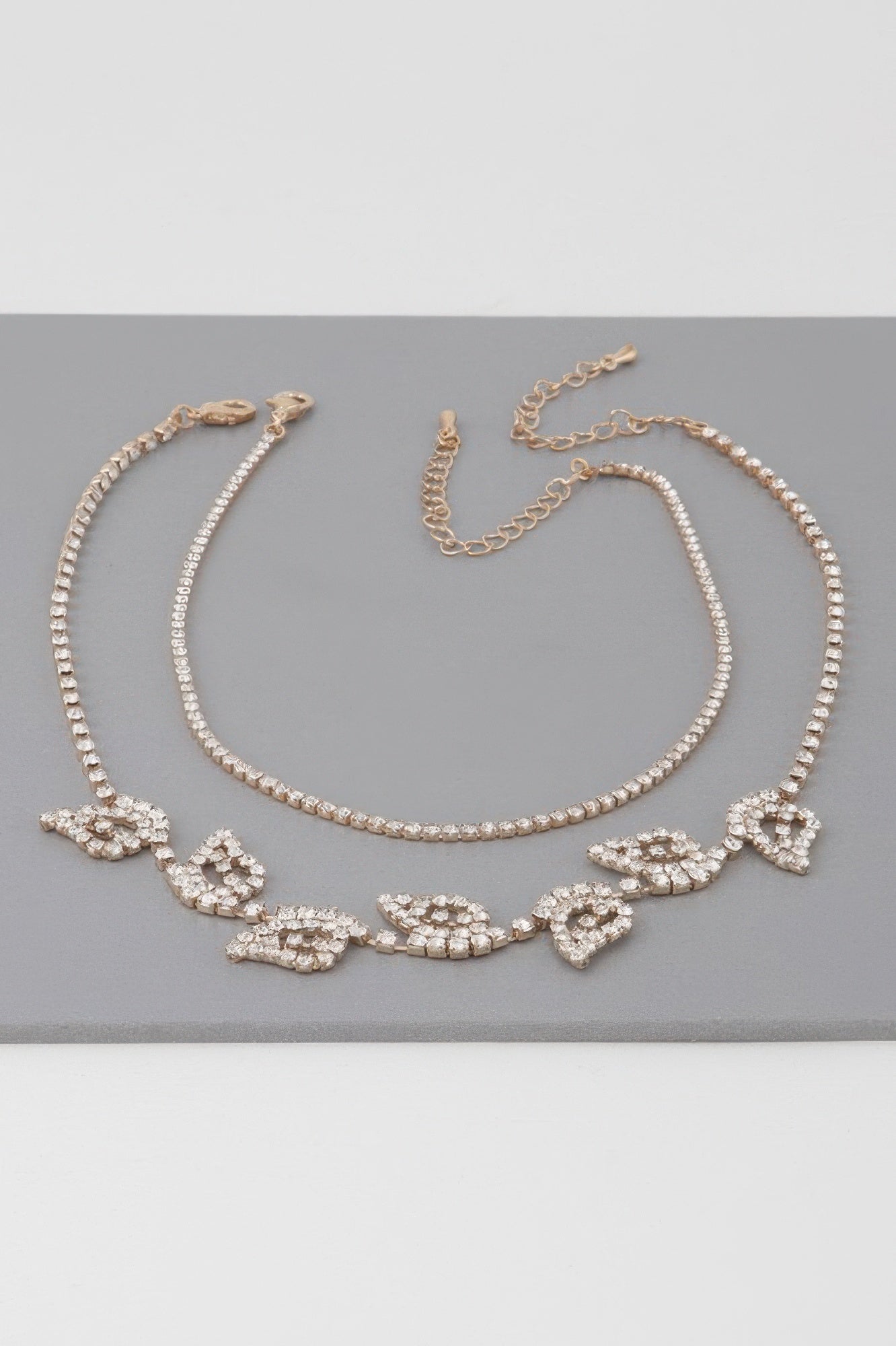 Gold clear rhinestone leaf choker necklace laid flat with clasp and linked chain