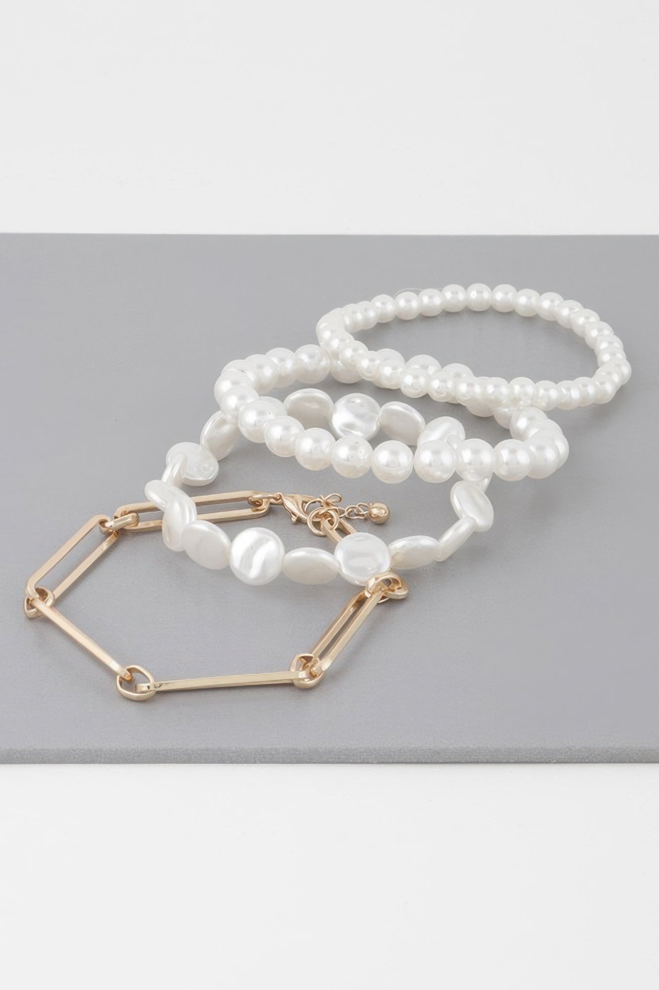 Multi faux pearl bracelet with gold-tone rectangular links and pearl strand loop
