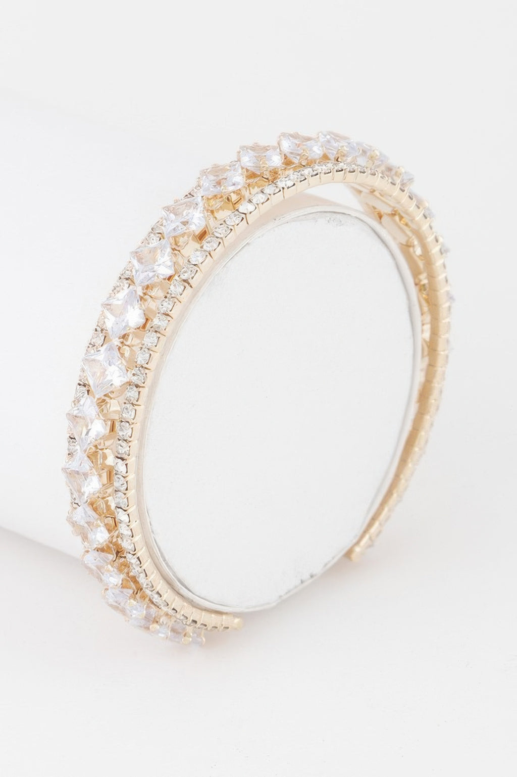 Gold-tone cubic rhinestone cuff bracelet with clear sparkle stones, open oval.