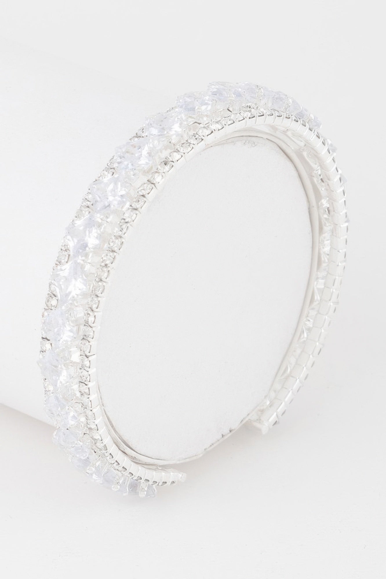 Silver-tone cubic rhinestone cuff bracelet with clear stones, open oval shape.