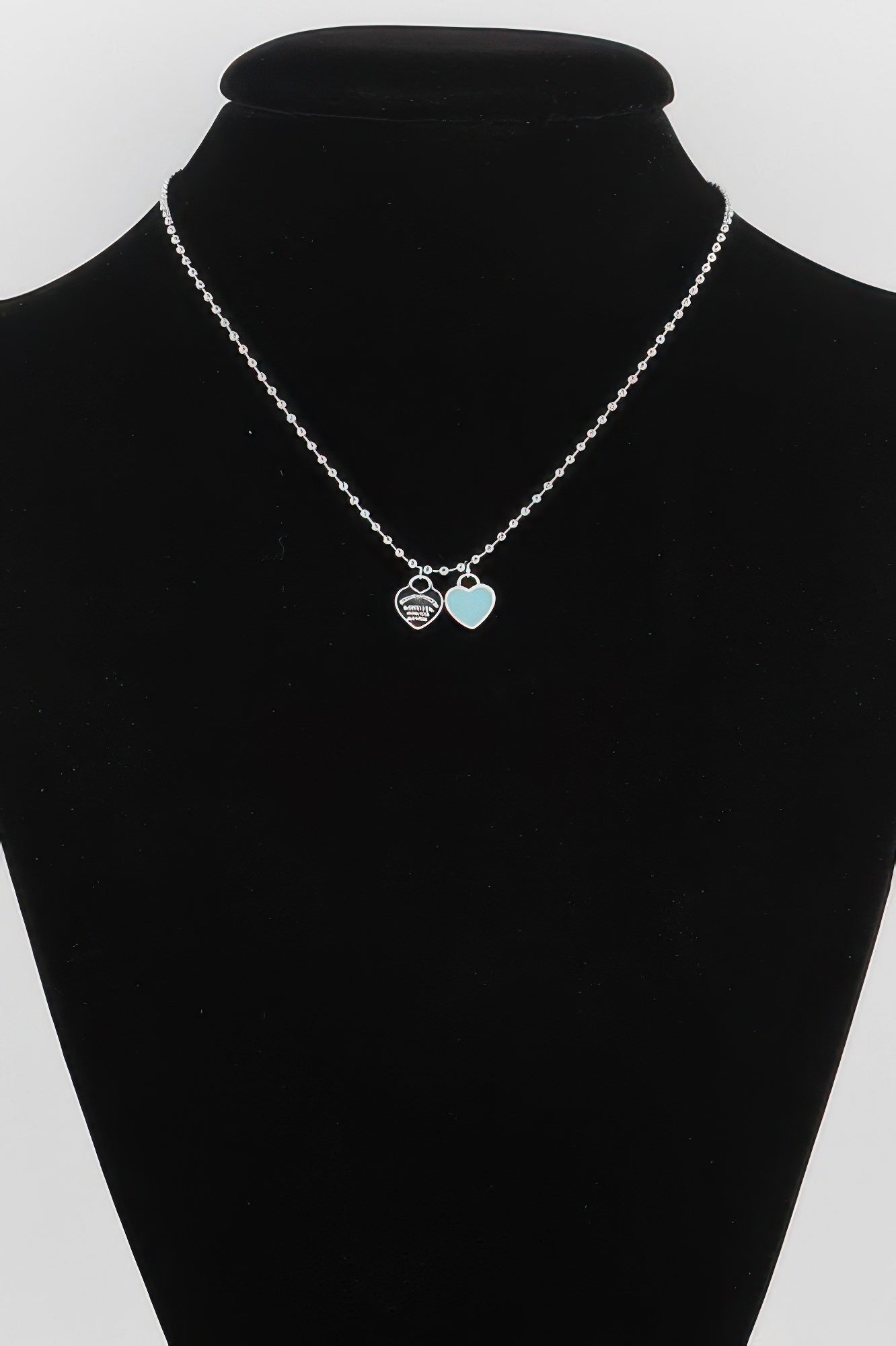 Heart pendant necklace with silver chain, one white and one light-blue heart charm