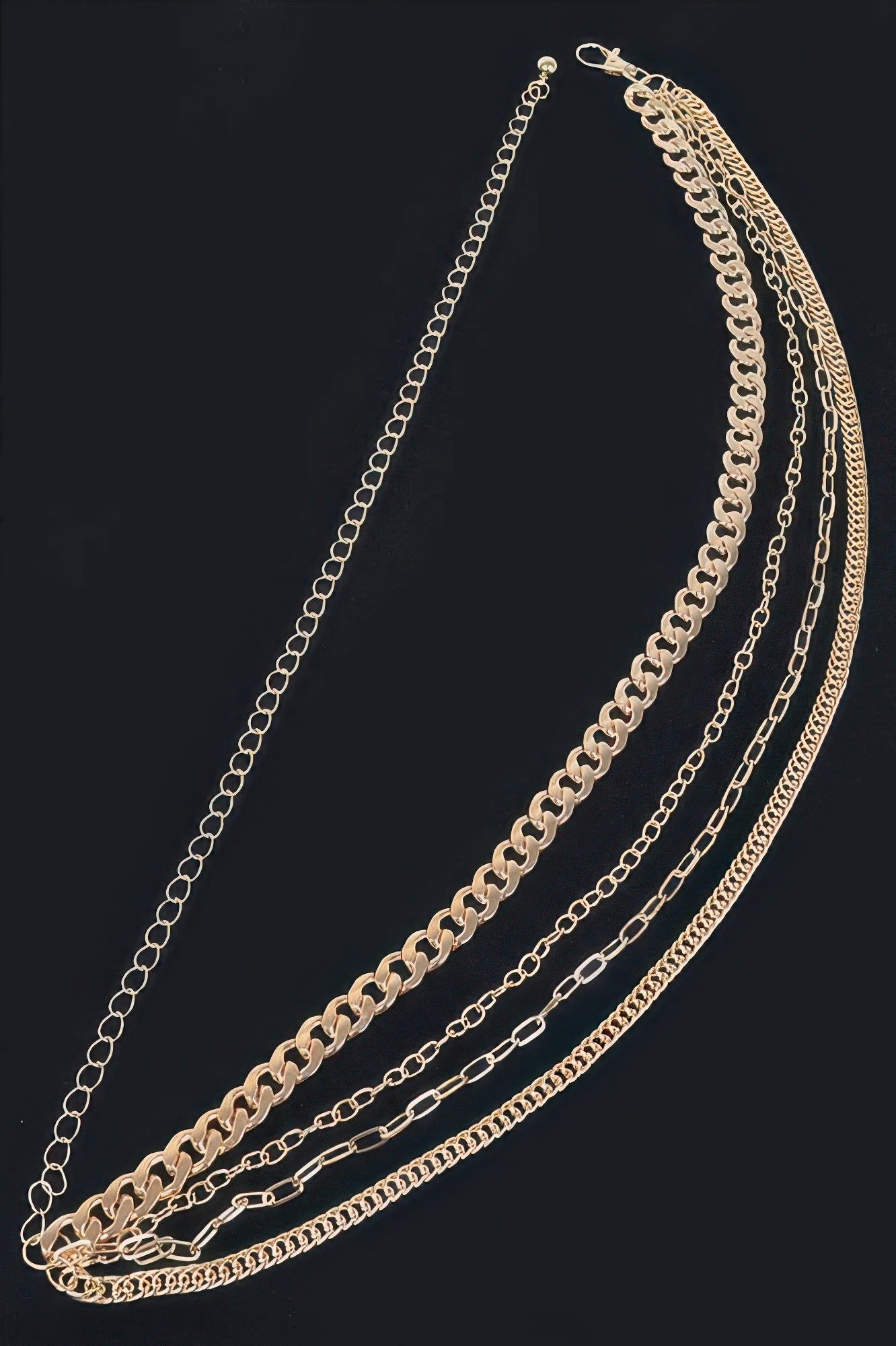 Gold-tone chain belt close-up: layered links and hook clasp