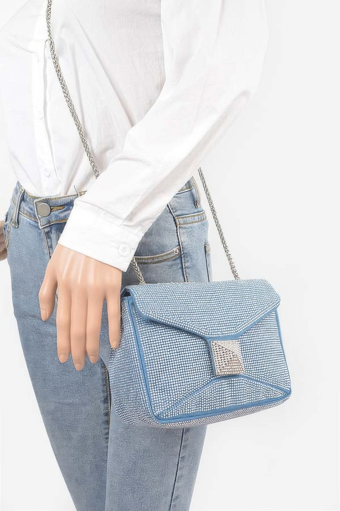 Light blue rhinestone denim clutch on shoulder with long silver chain strap