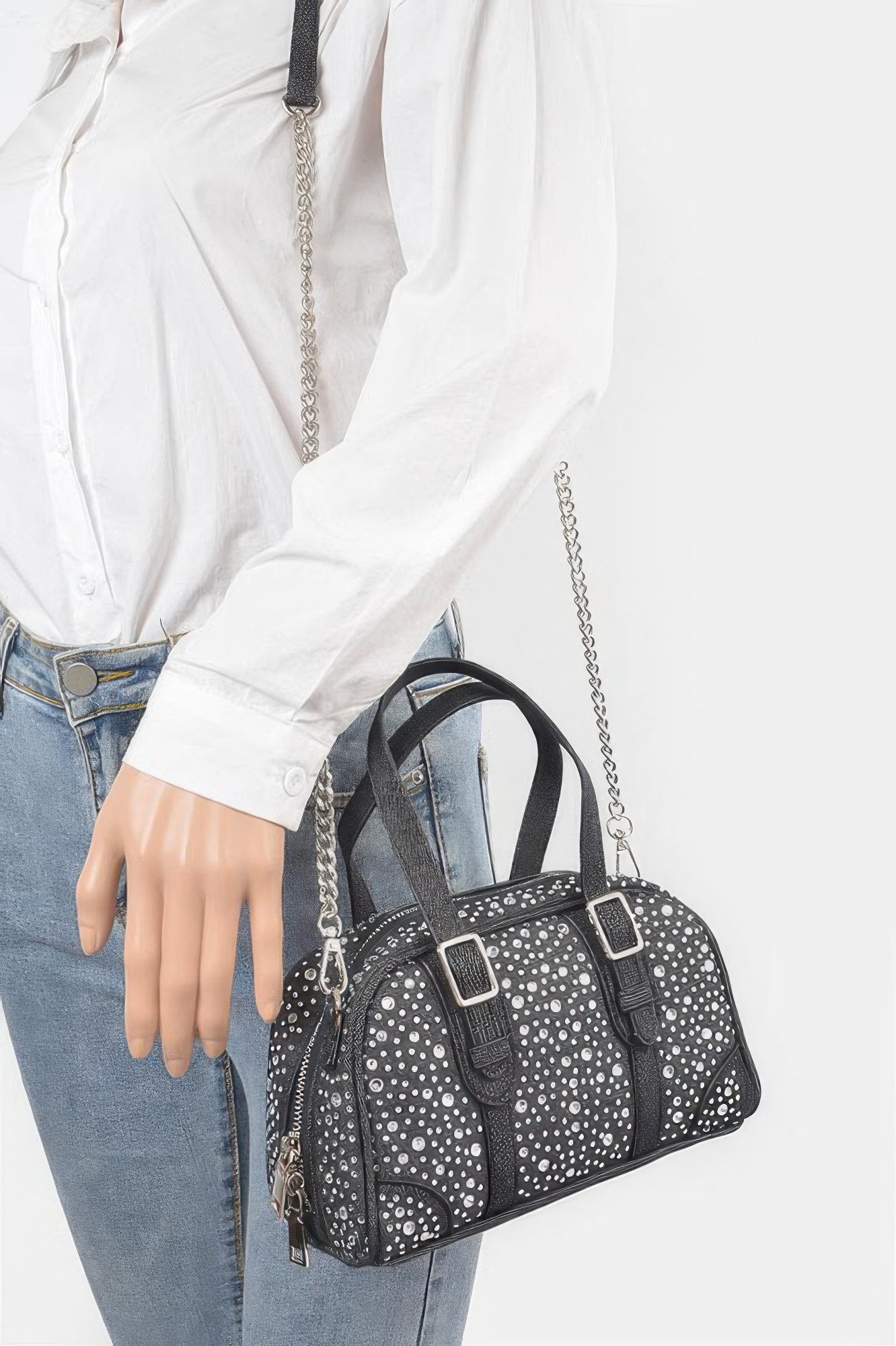 Black denim crossbody bag on model with silver chain shoulder strap and zip top