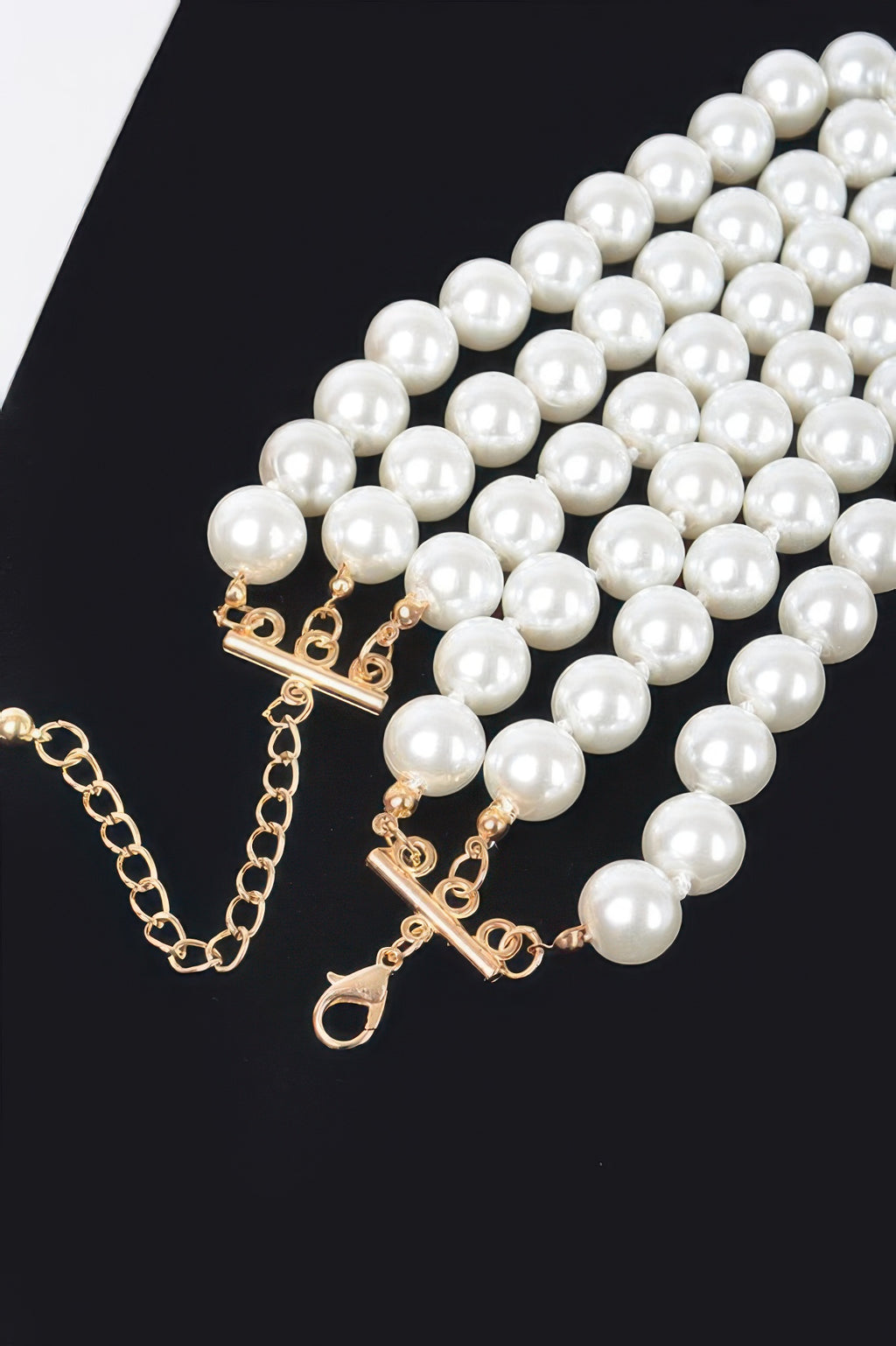 Pearl strand necklace detail with gold toggle clasp and faux-pearl drop earrings