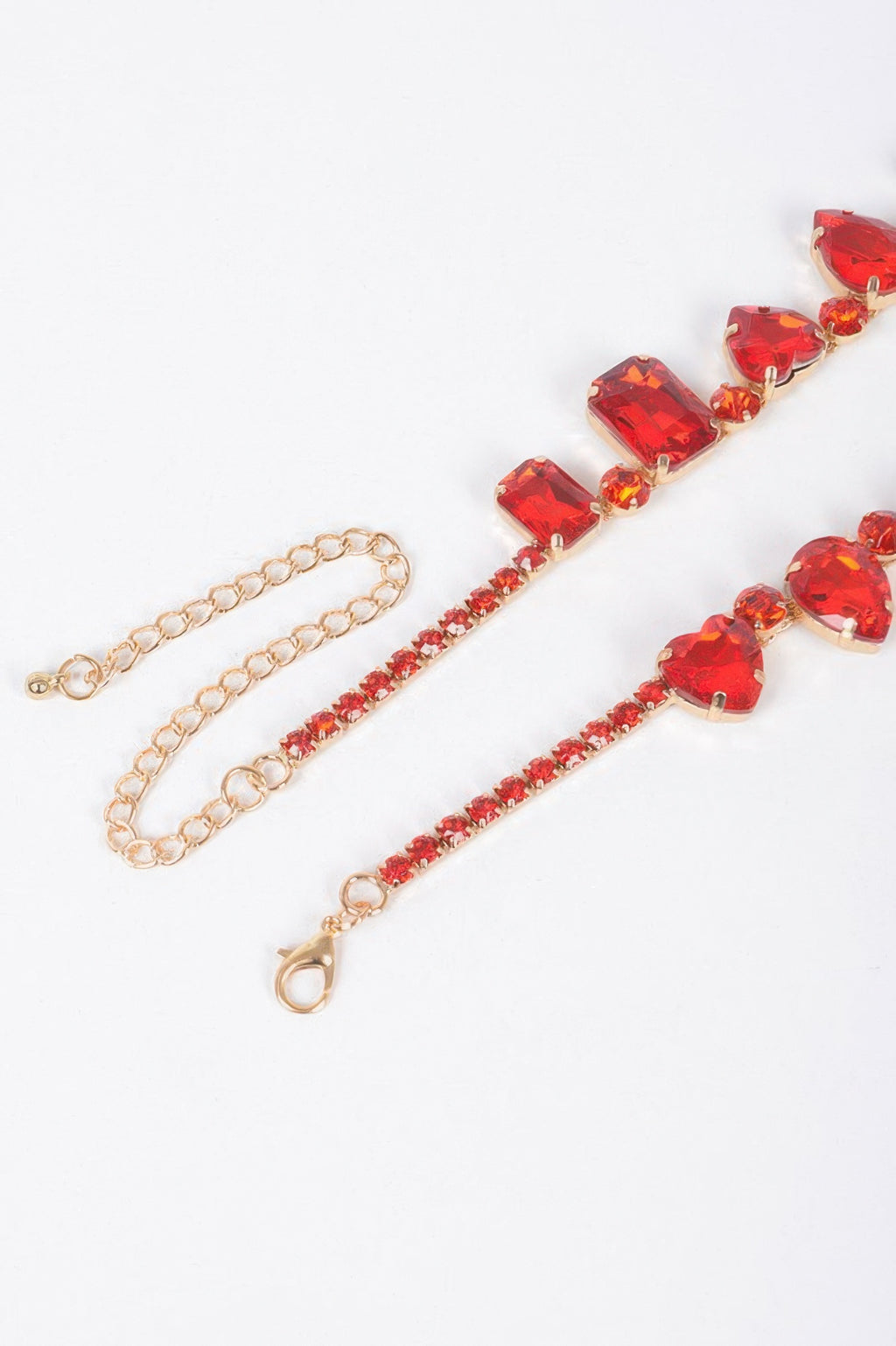 Red faceted heart stone necklace with gold-tone chain and heart-link center