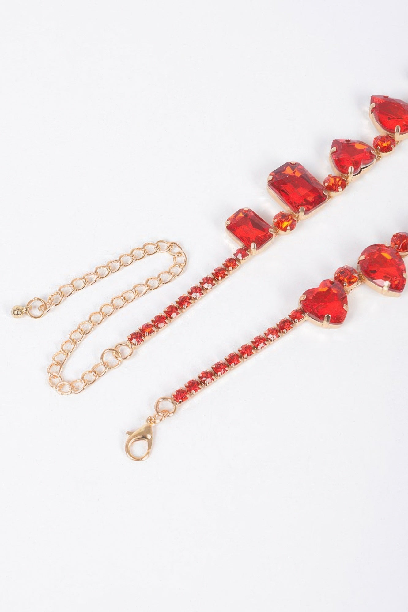 Red faceted heart stone necklace with gold-tone chain and heart-link center