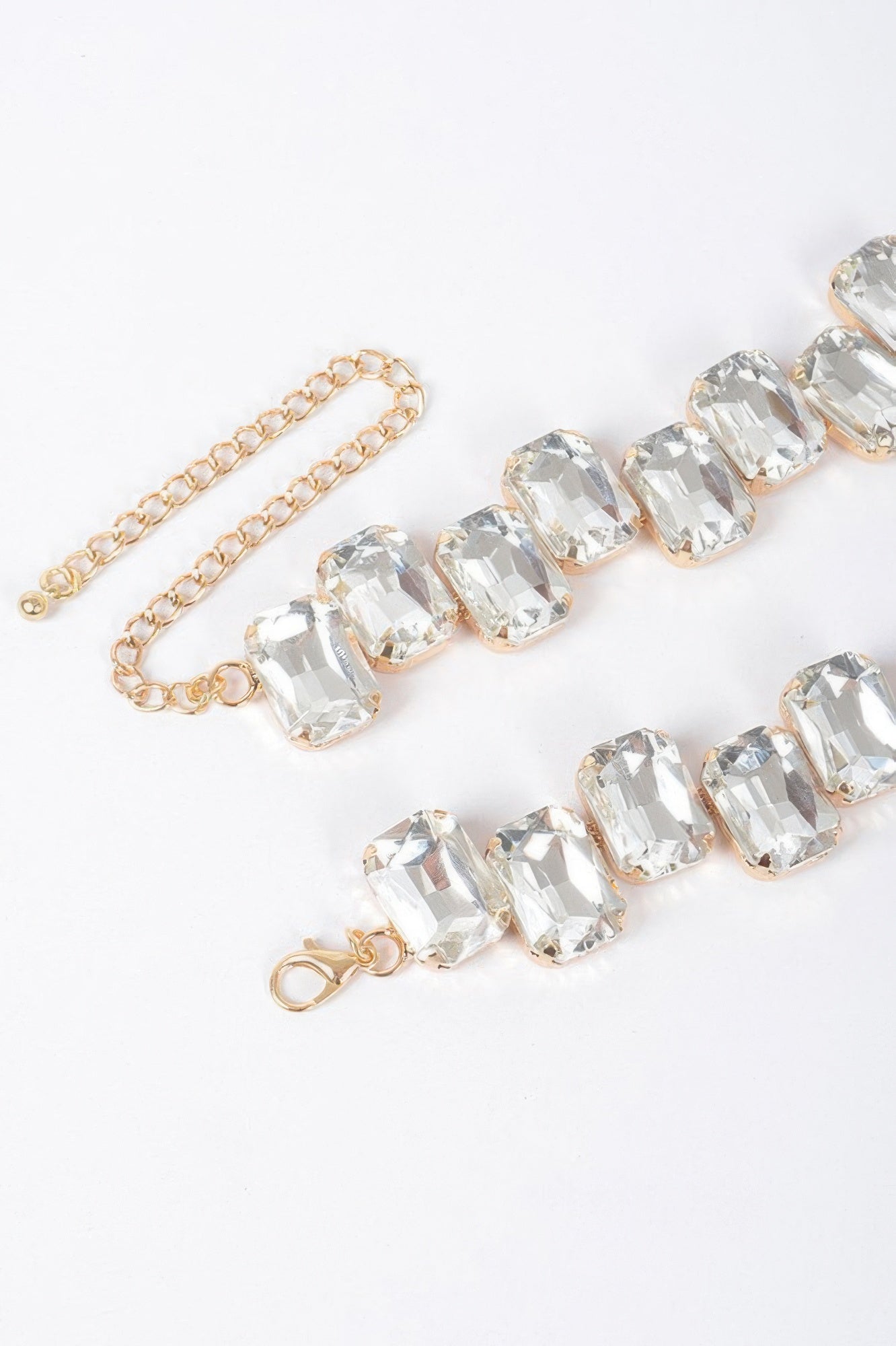 Close view of clear faceted stone bead necklace with gold-tone chain and hooks