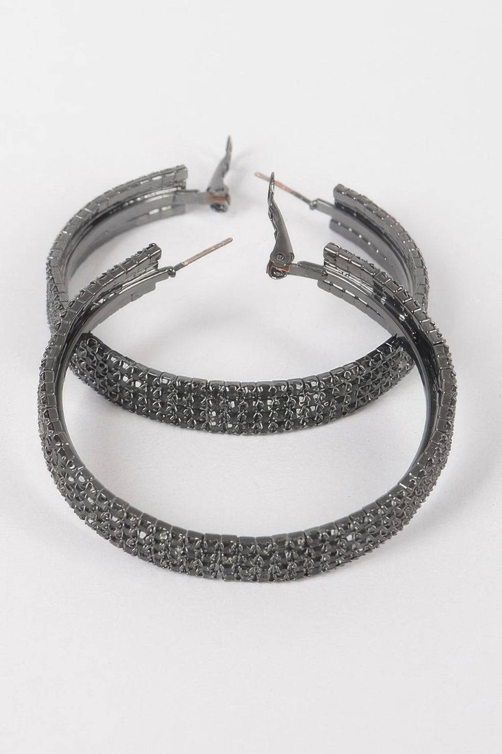Hematite-tone rhinestone hoop earrings with hinged clasp, textured pavé band