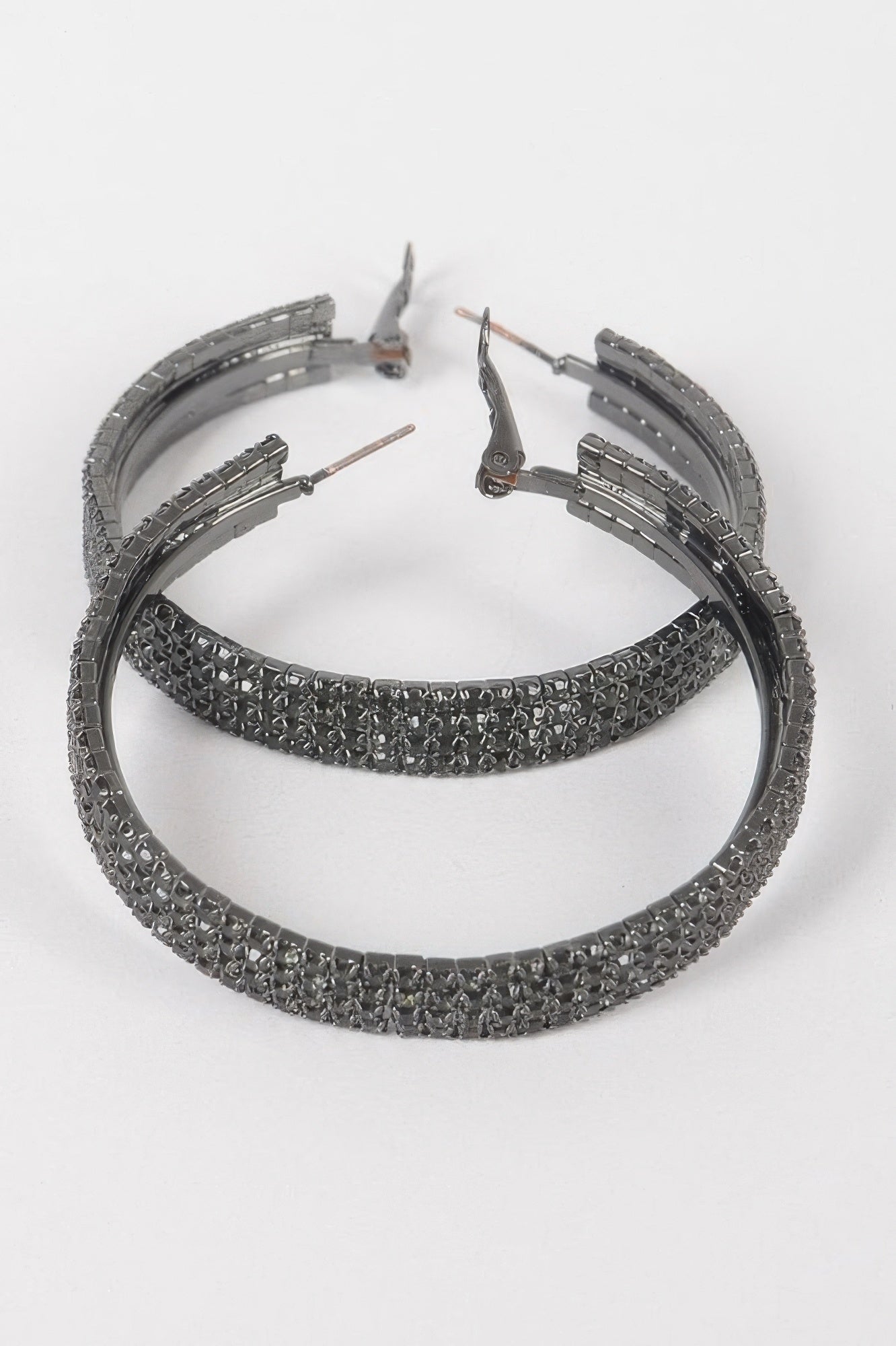 Hematite-tone rhinestone hoop earrings with hinged clasp, textured pavé band