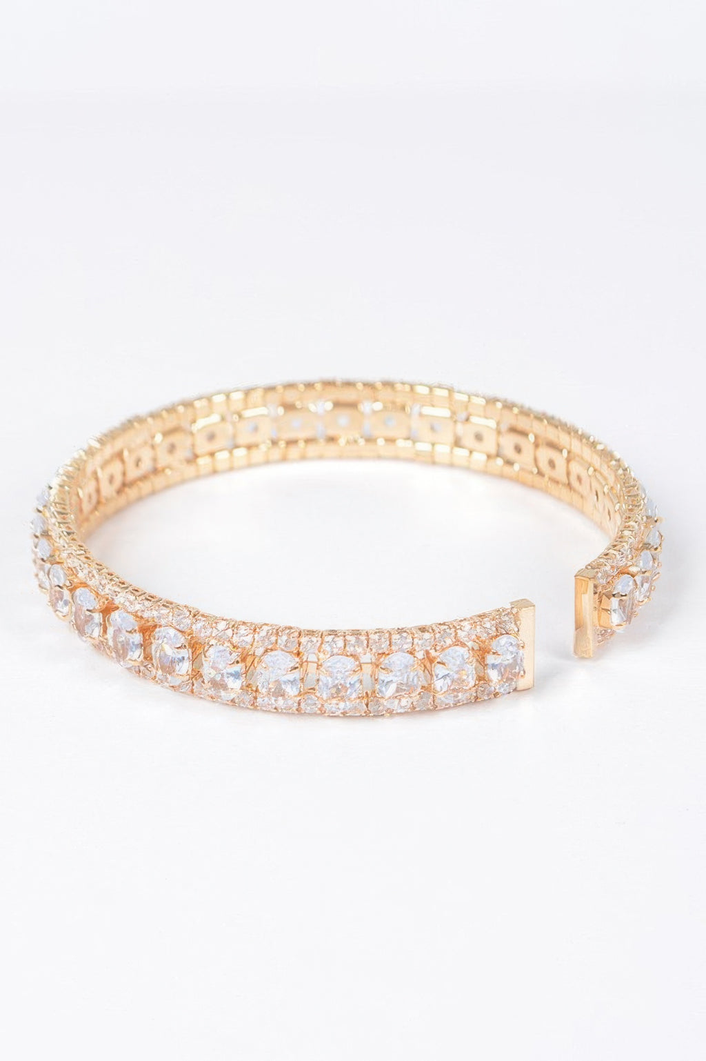 Gold-toned open cuff bracelet with clear cubic zirconia row and clasp detail