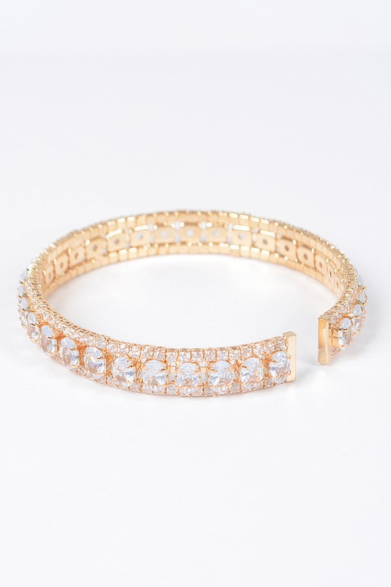 Gold-toned open cuff bracelet with clear cubic zirconia row and clasp detail