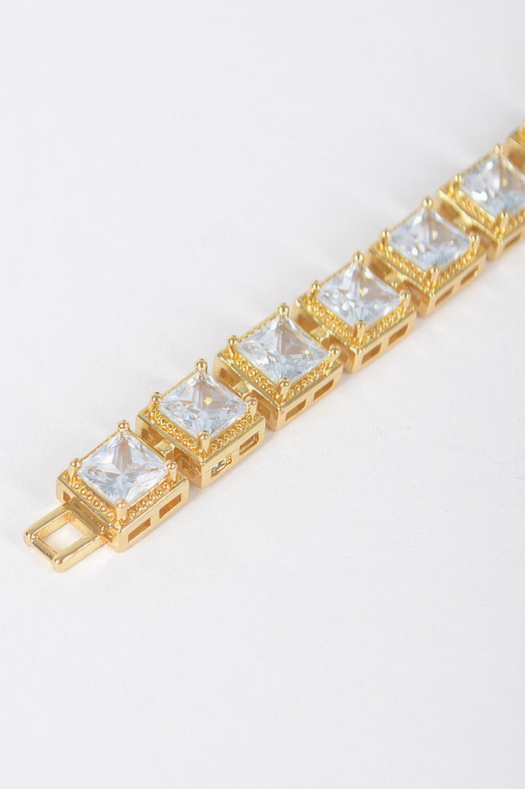 Gold-tone cubic zirconia bracelet detail with clear square stones and beveled settings