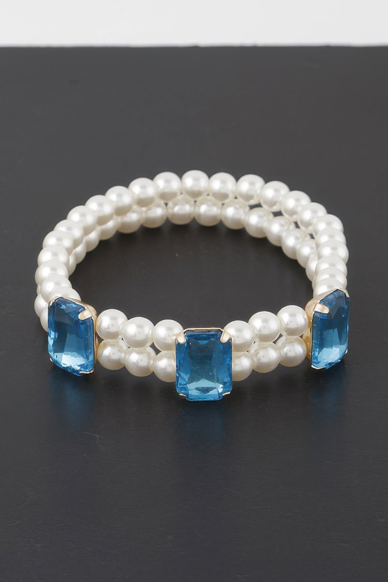 Pearl beaded bracelet with three light blue rhinestone square stones and gold-tone bar