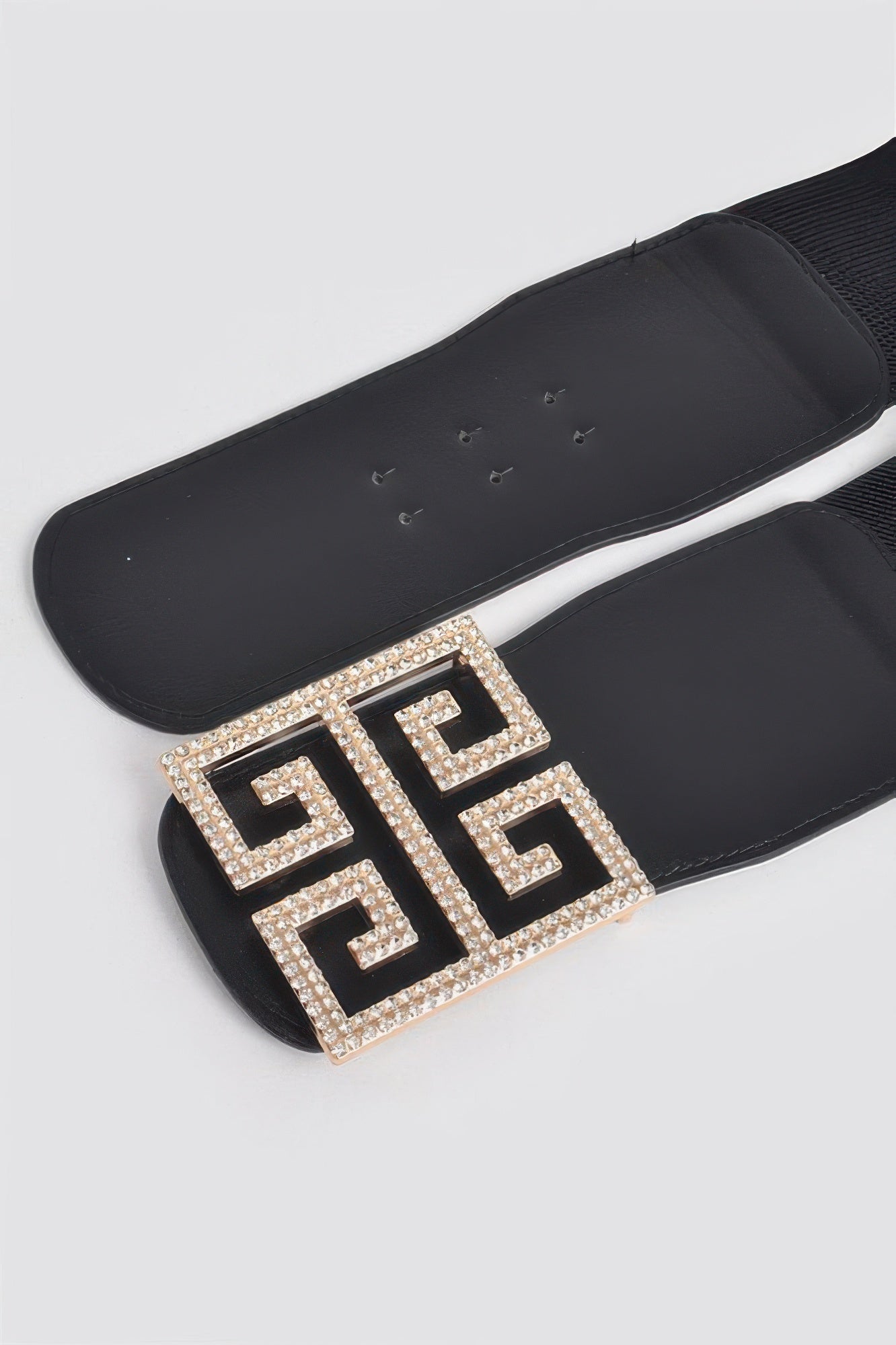Close-up: black stretch belt with gold-toned rhinestone square buckle