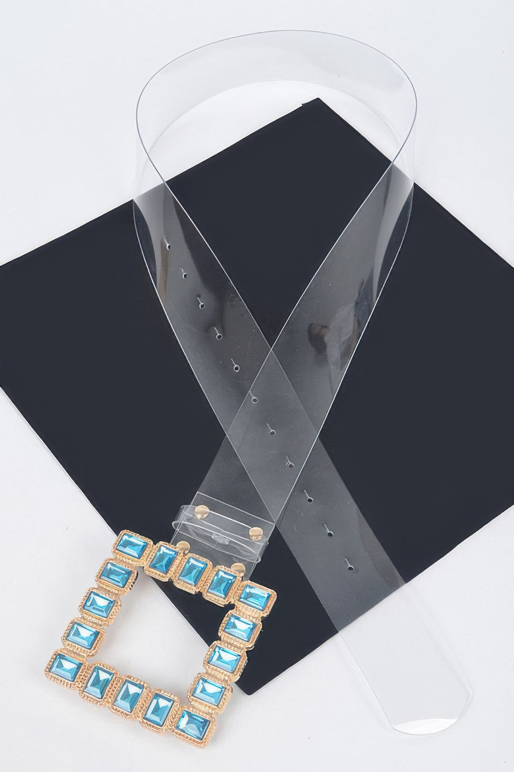 Stone buckle faux leather belt with blue square stones on clear strap, side view