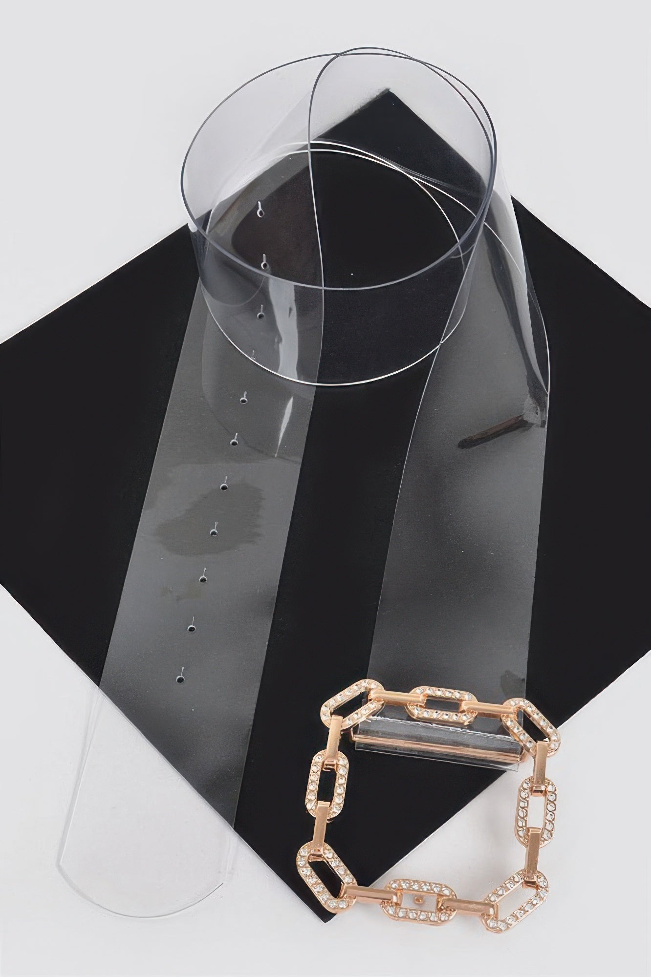 Gold chain-link rhinestone buckle on clear transparent belt, angled view