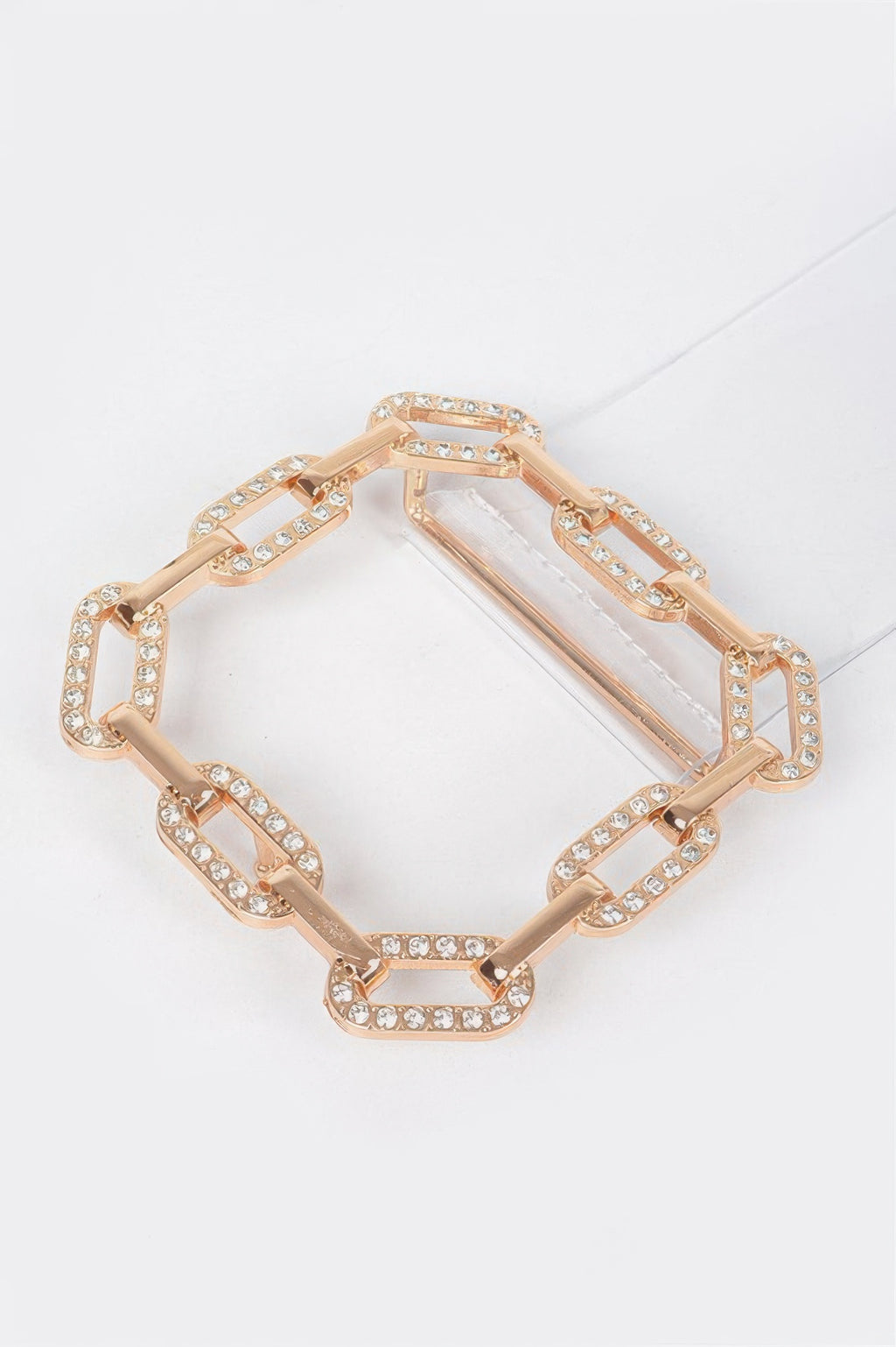 Gold rhinestone buckle with rectangular and oval link chain, flat lay