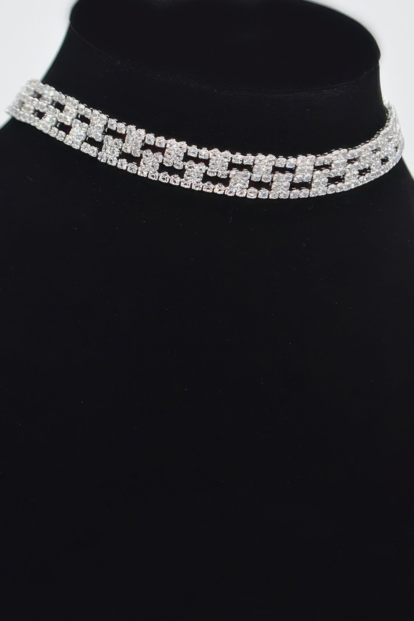 Rhinestone choker with repeating silver square settings along the band