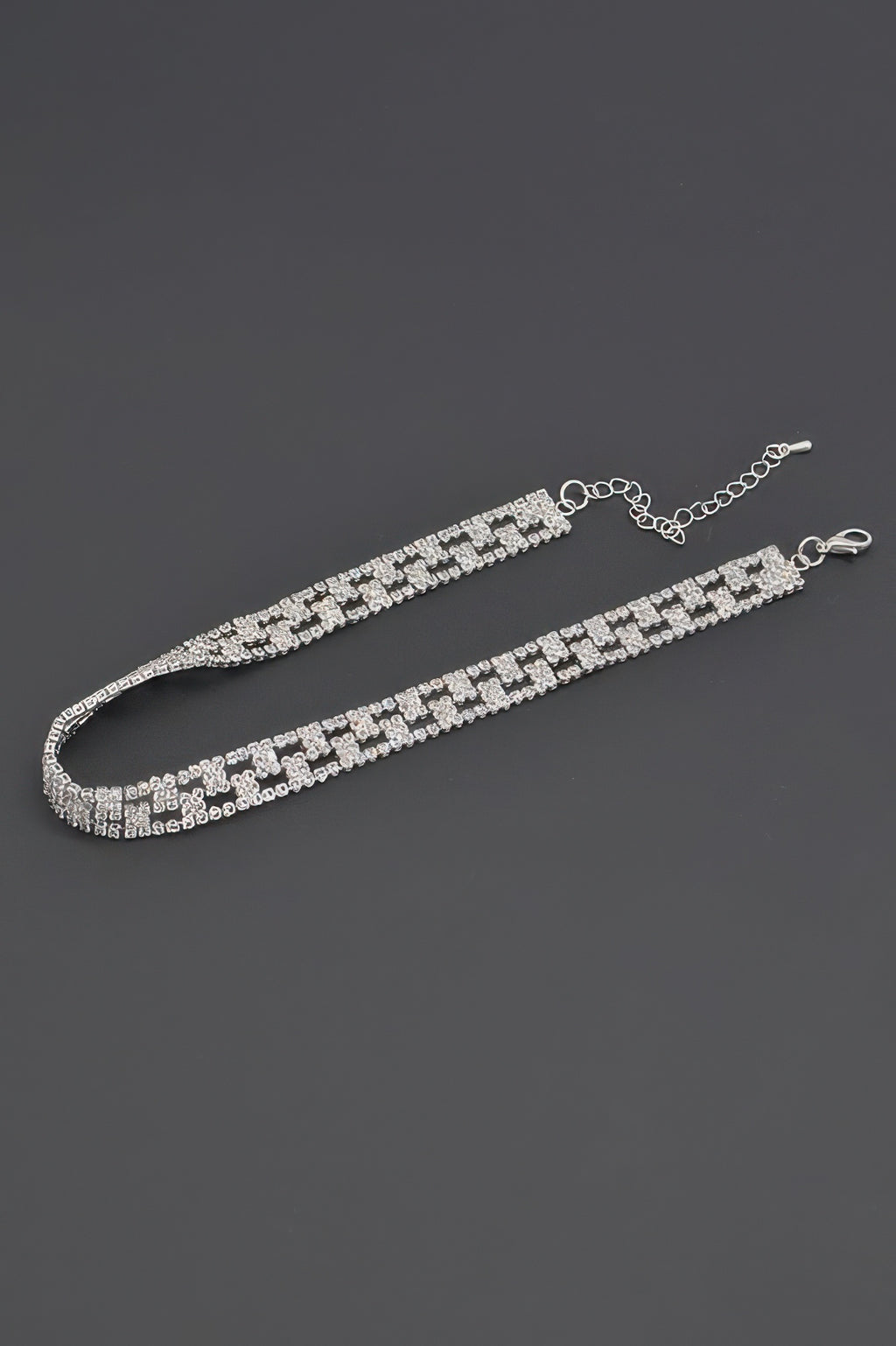 Aligned rhinestone choker laid flat with silver clasp and chain extender