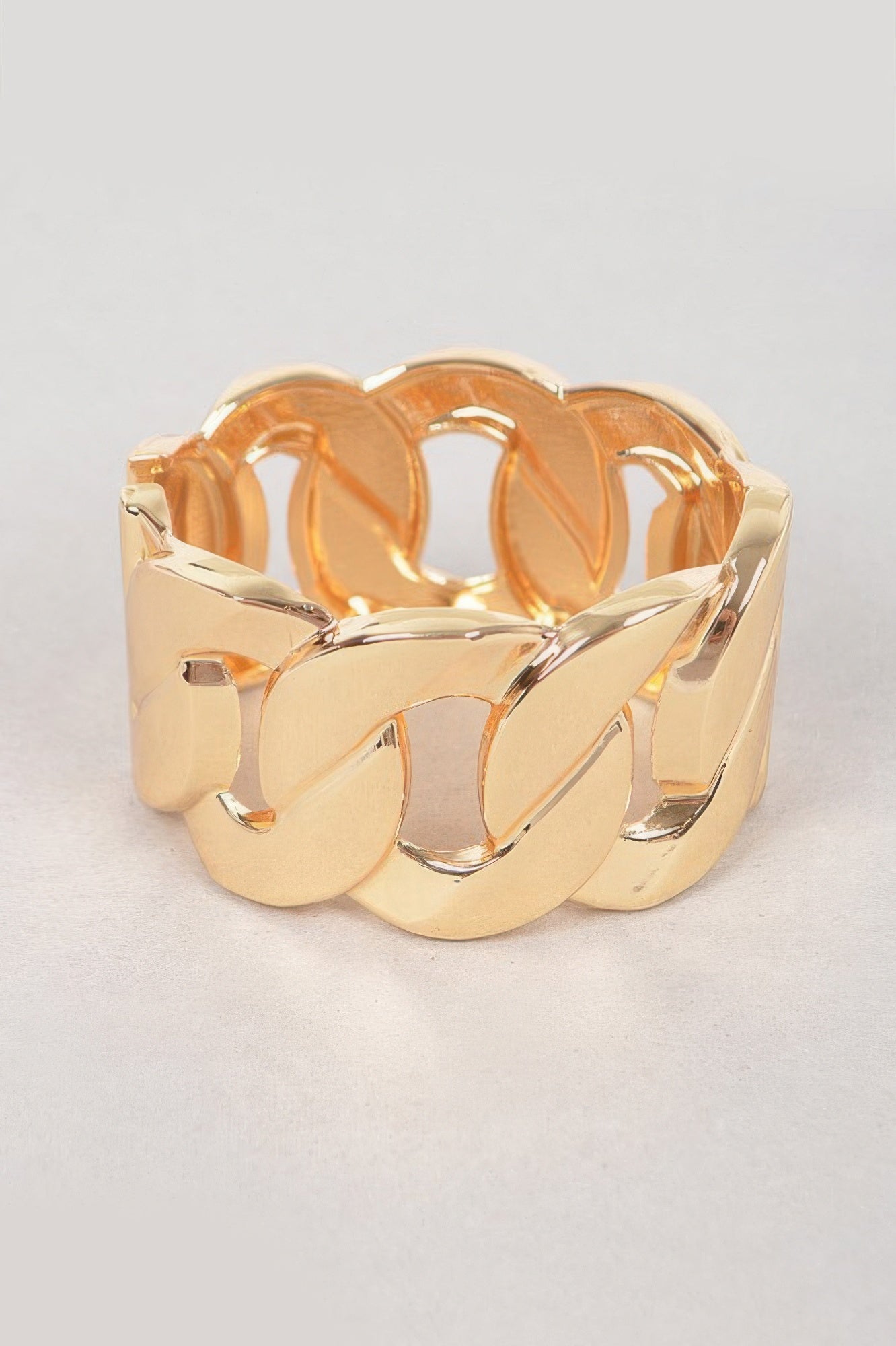 Wide gold chain metal bracelet with chunky linked segments and glossy finish