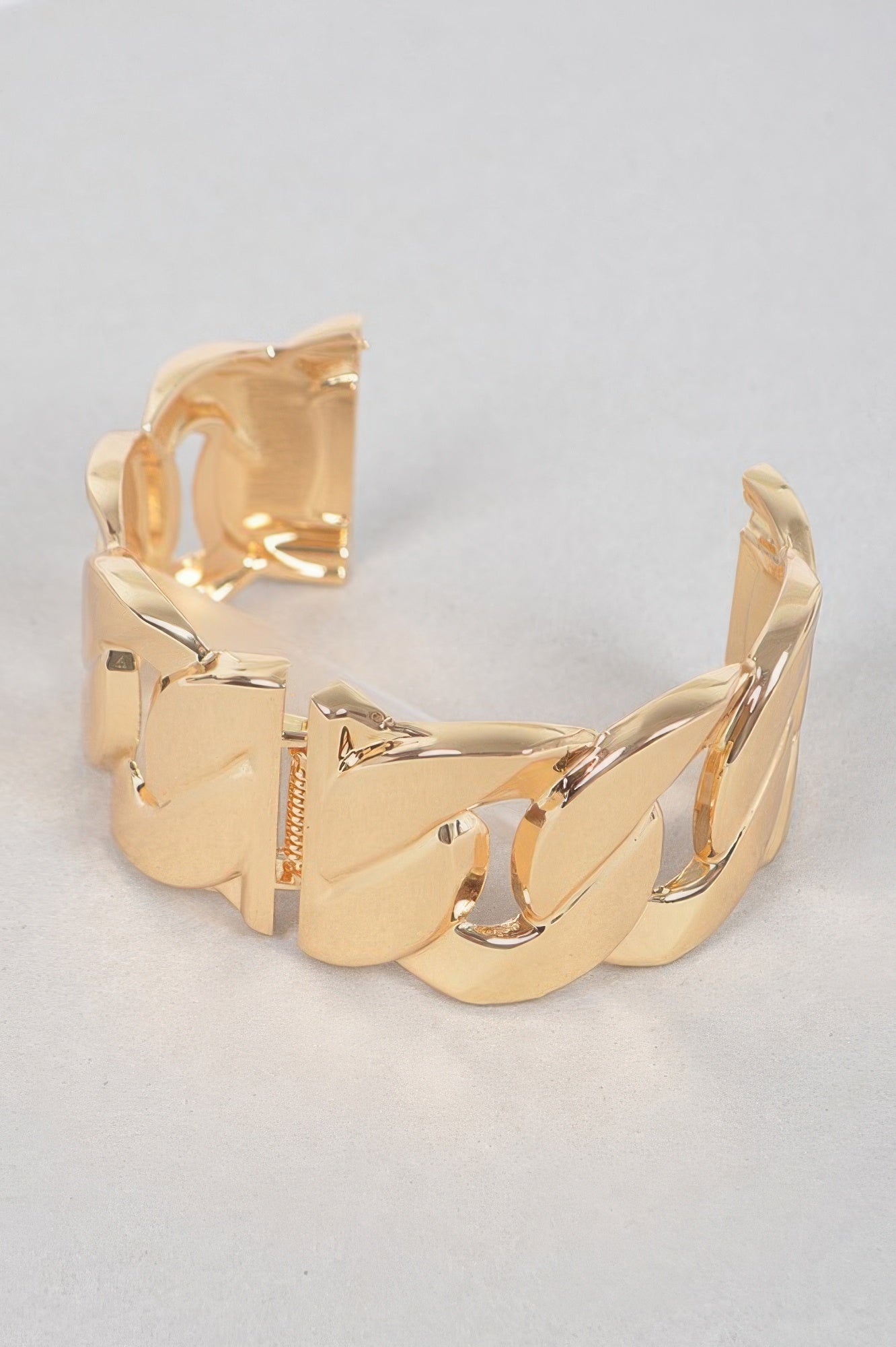 Gold chunky chain metal bracelet on a flat view, showing large linked panels