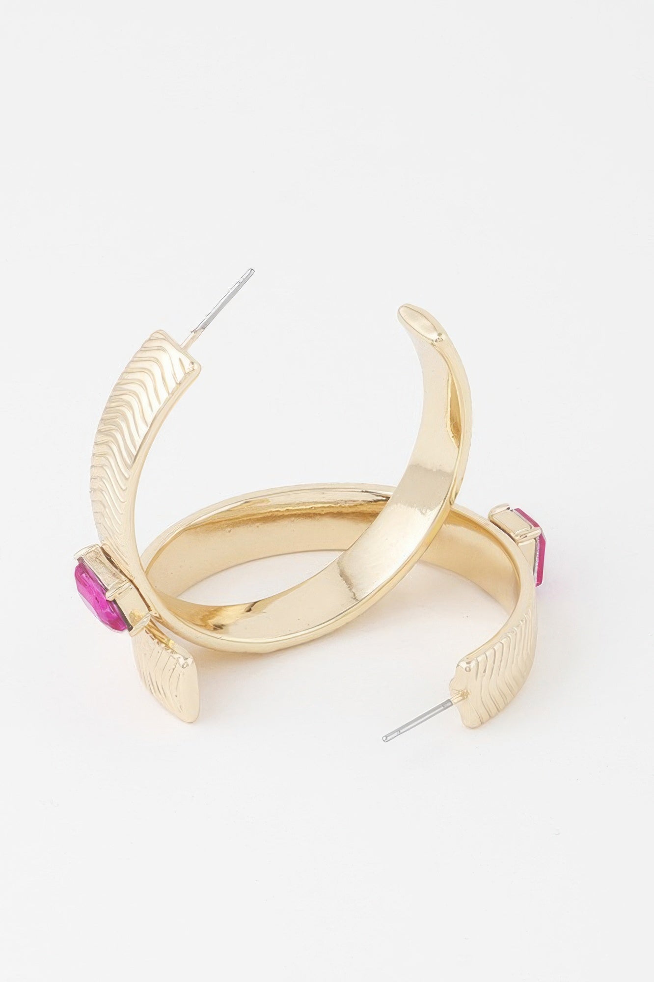 Gold hoop earrings with glossy inner curve, textured outer arc, pink rhinestone blocks
