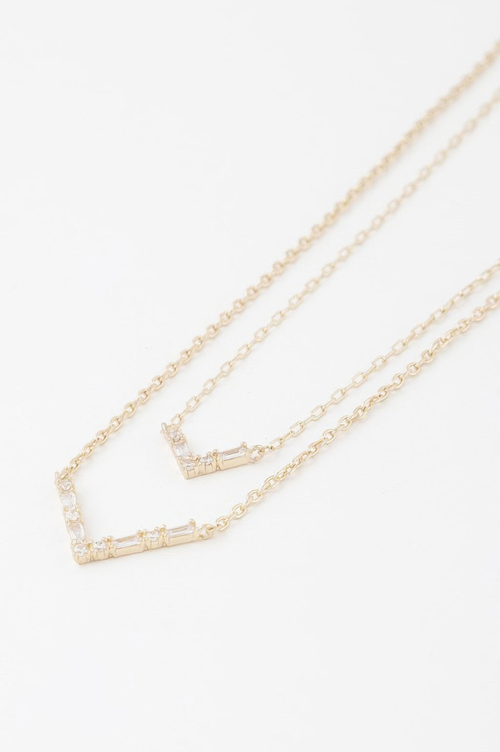 Gold-tone double V crystal necklace close-up showing two rectangular crystal settings