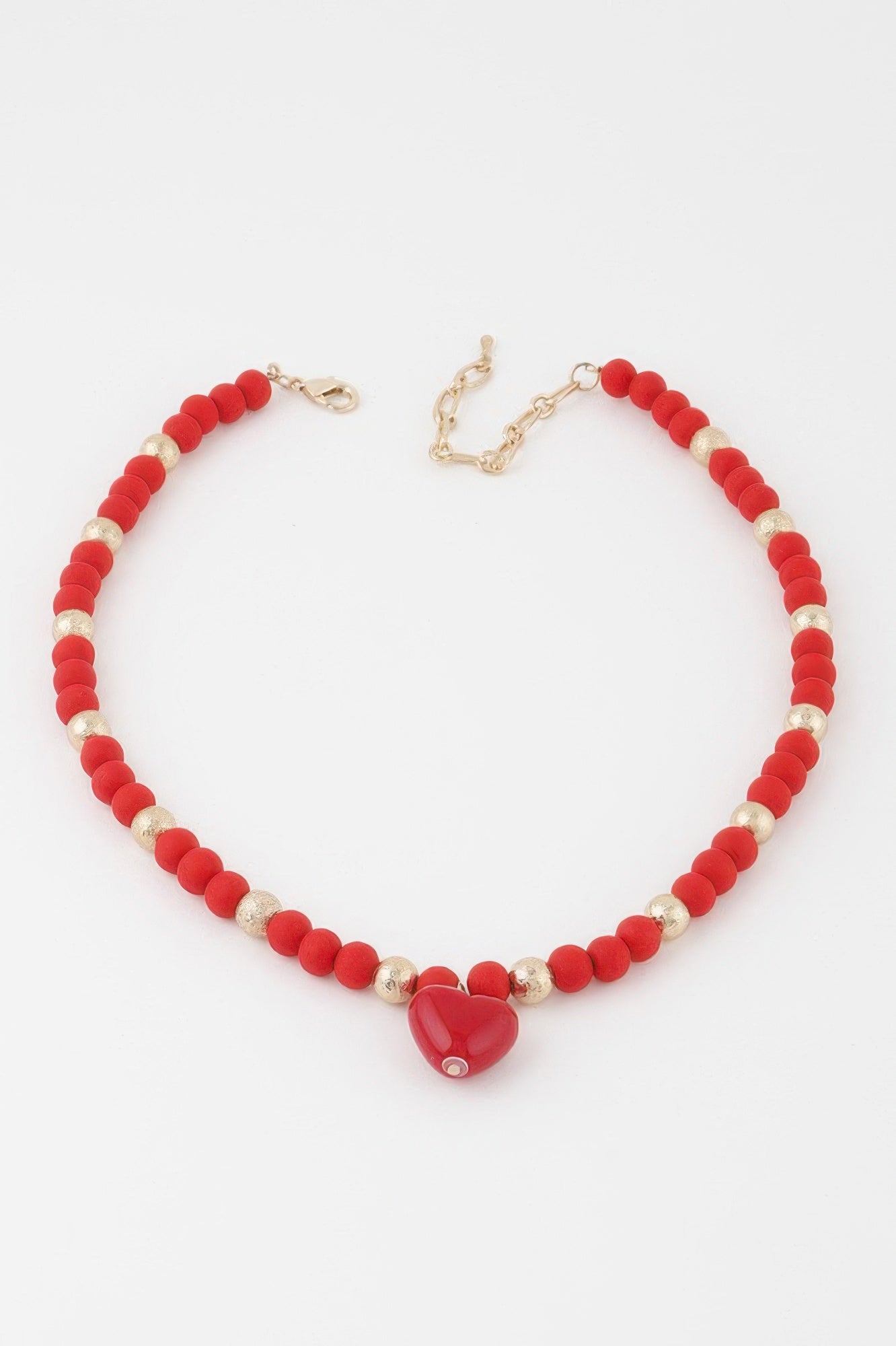 Red beaded heart necklace laid flat with heart pendant on gold-tone chain