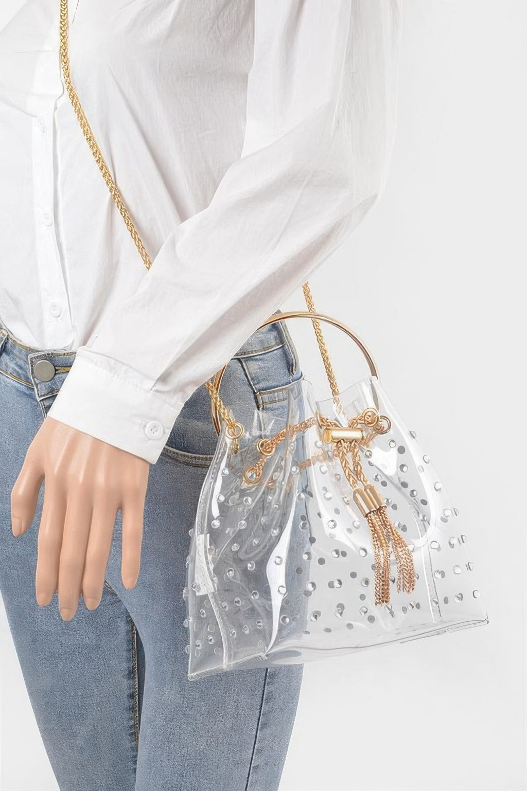 Clear faux pearl bucket bag worn on shoulder with gold chain and tassel pulls