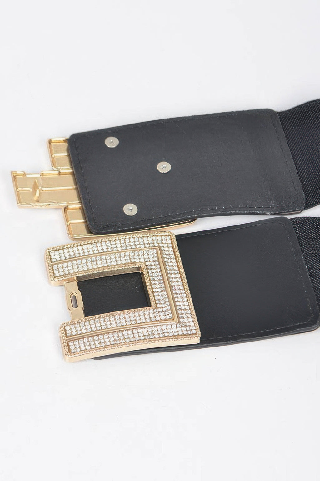 Close-up of black elastic belt buckle with rhinestones and gold frame.