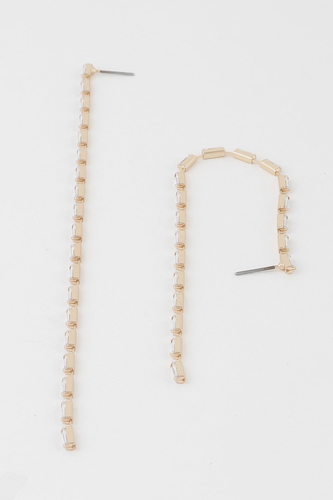 Long crystal bar drop earrings with gold-tone links and clear stones, one shown at angle