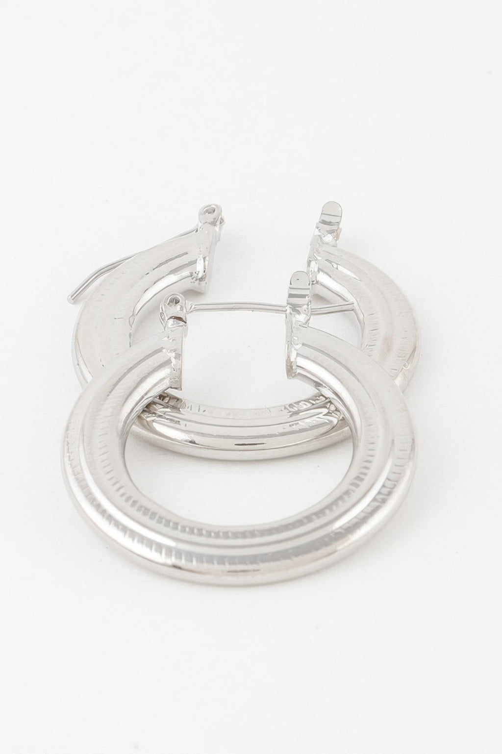 Minimal flat hoop earrings in silver, textured outer ring with hinged posts