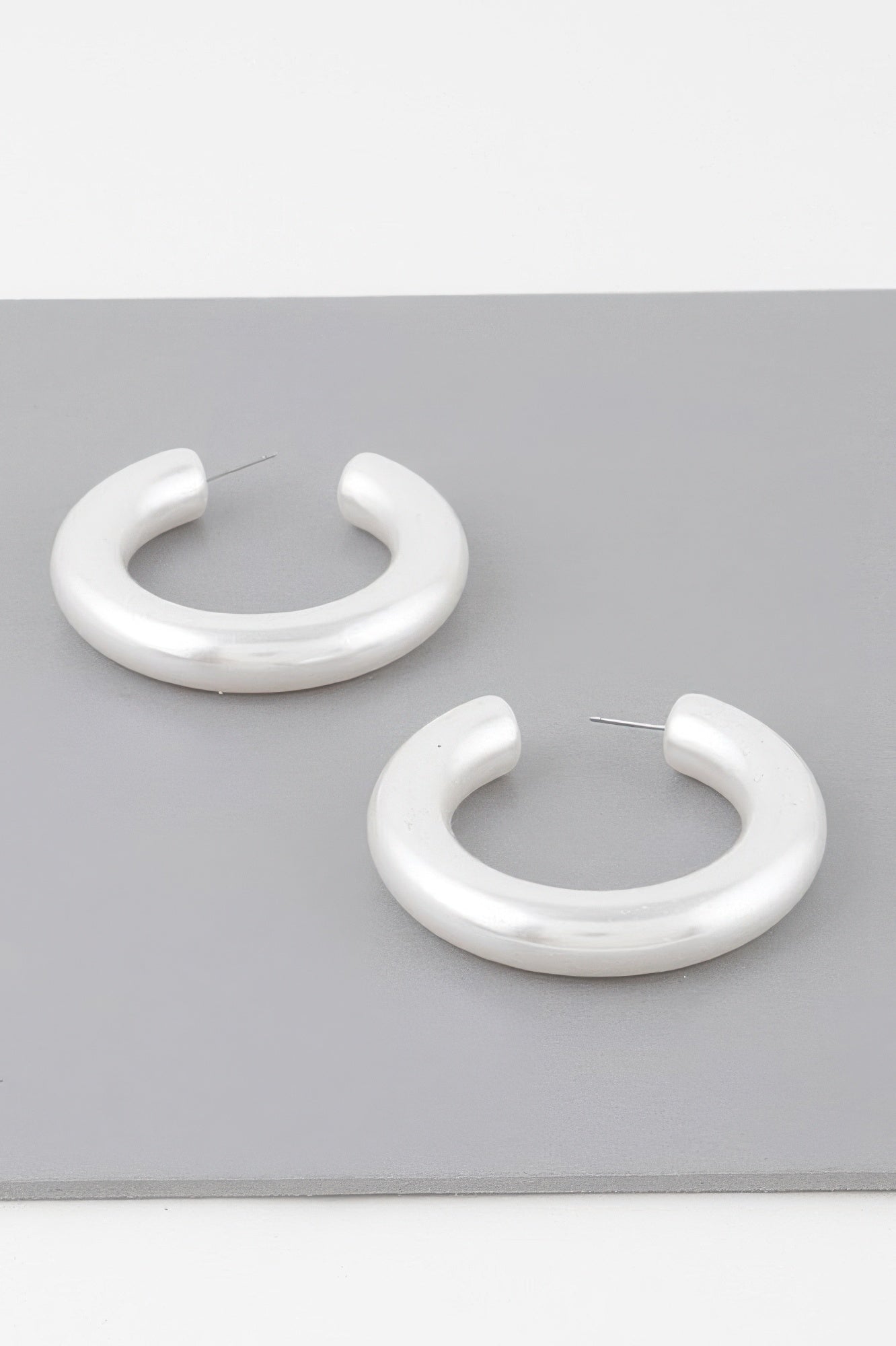 Polished cream hoop earrings, two curved hoops with stud backs