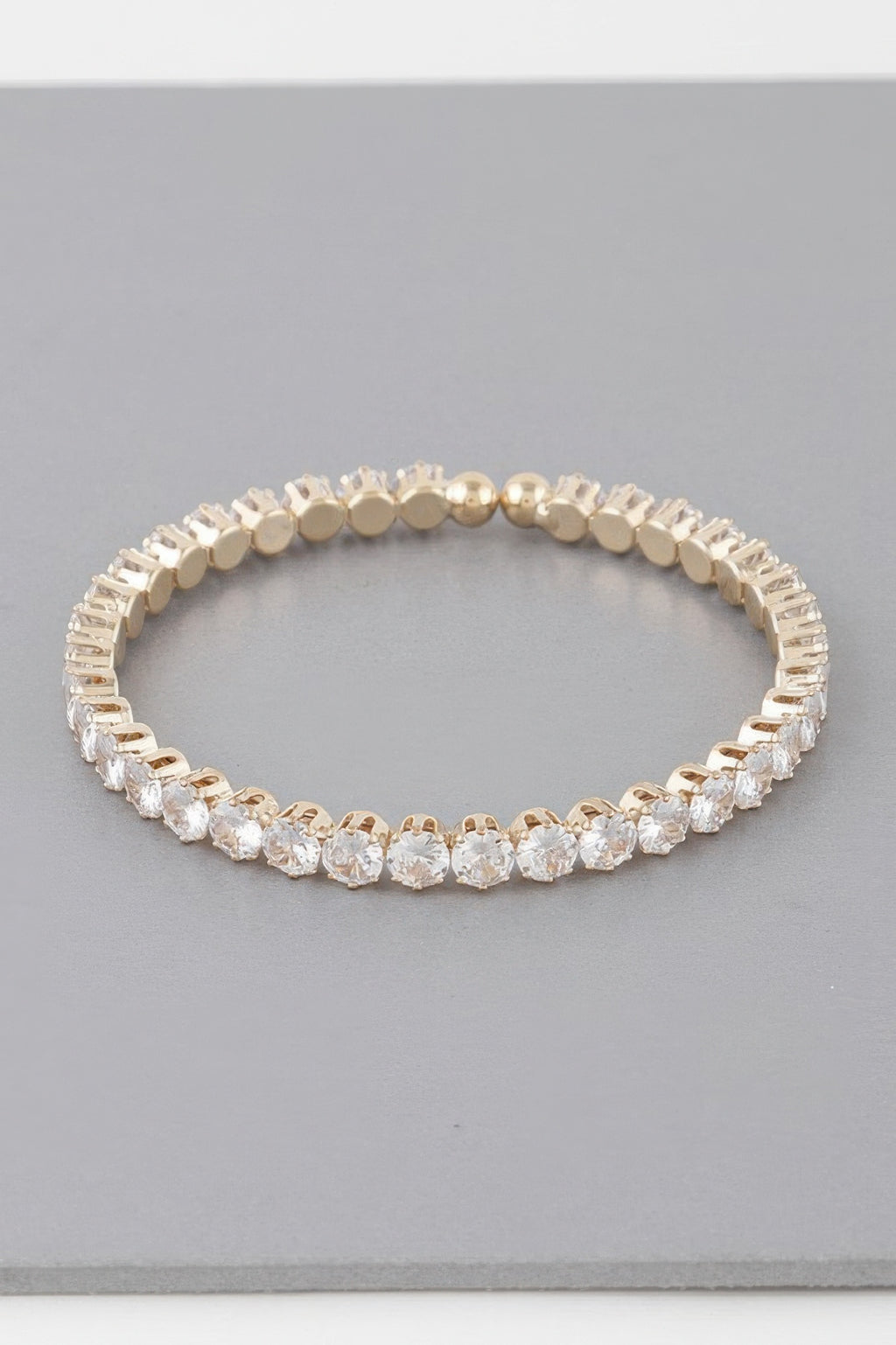 Rhinestone cuff bracelet in gold-tone, closely set clear rhinestones around
