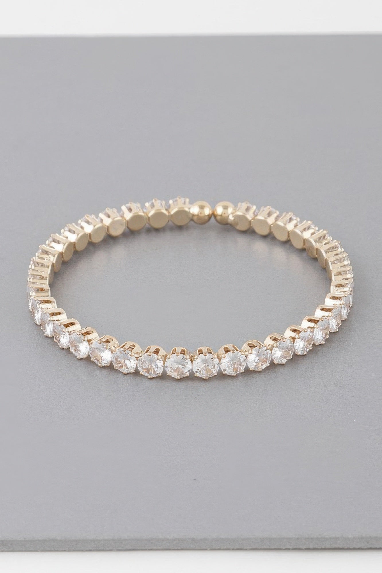 Rhinestone cuff bracelet in gold-tone, closely set clear rhinestones around