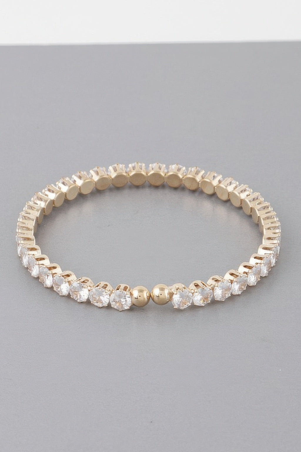 Gold-tone rhinestone cuff bracelet with clear gem-like stones and round bezel links