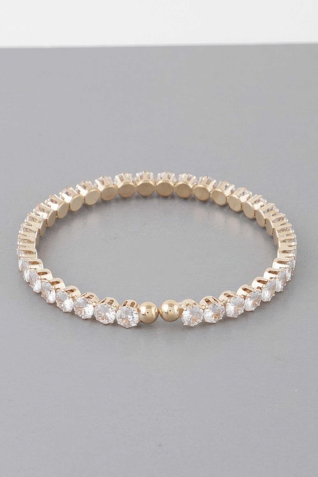 Gold-tone rhinestone cuff bracelet with clear gem-like stones and round bezel links