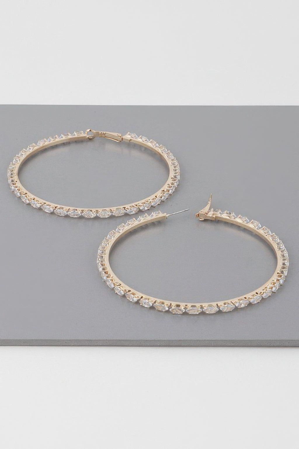 Teardrop jeweled hoop earrings, two gold-tone hoops with clear stones
