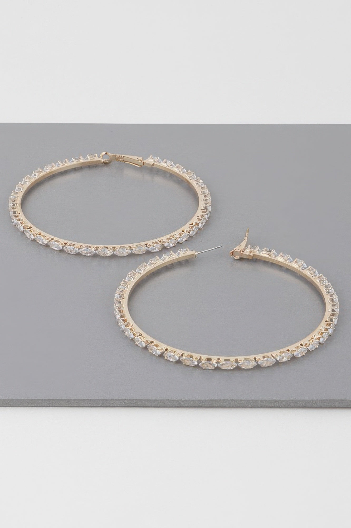 Teardrop jeweled hoop earrings, two gold-tone hoops with clear stones