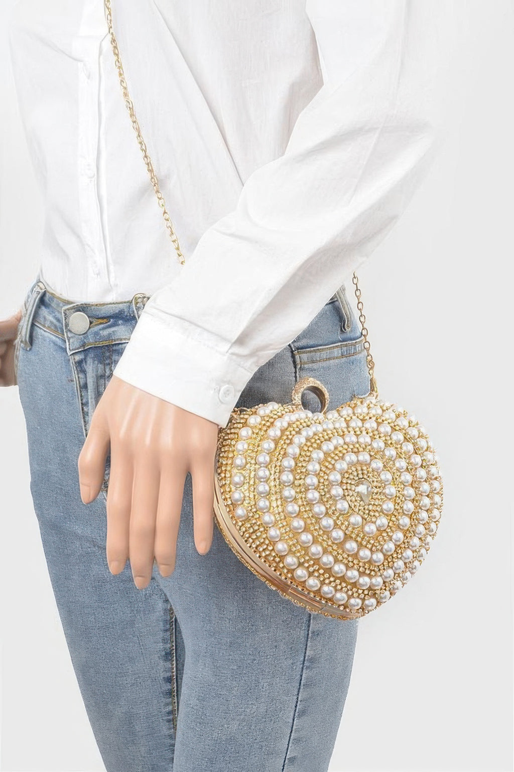 Heart-shaped gold clutch with pearl beadwork worn crossbody with gold chain