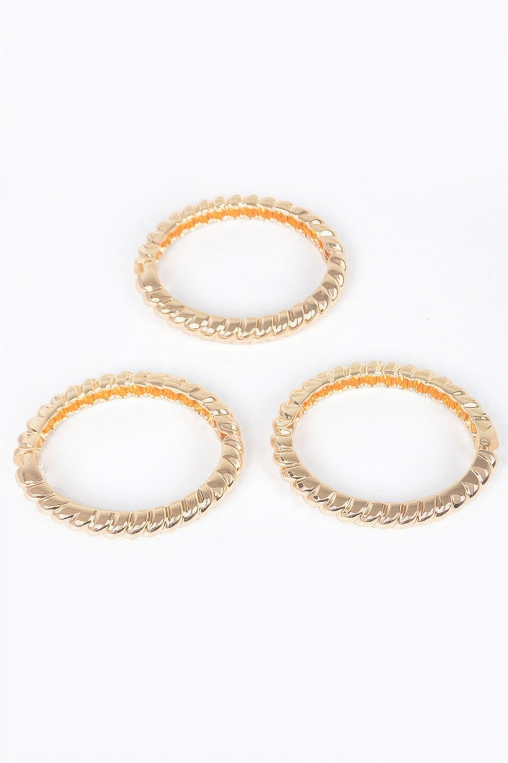 Three-piece metal bangle set, gold-tone bangles with orange-accent insets