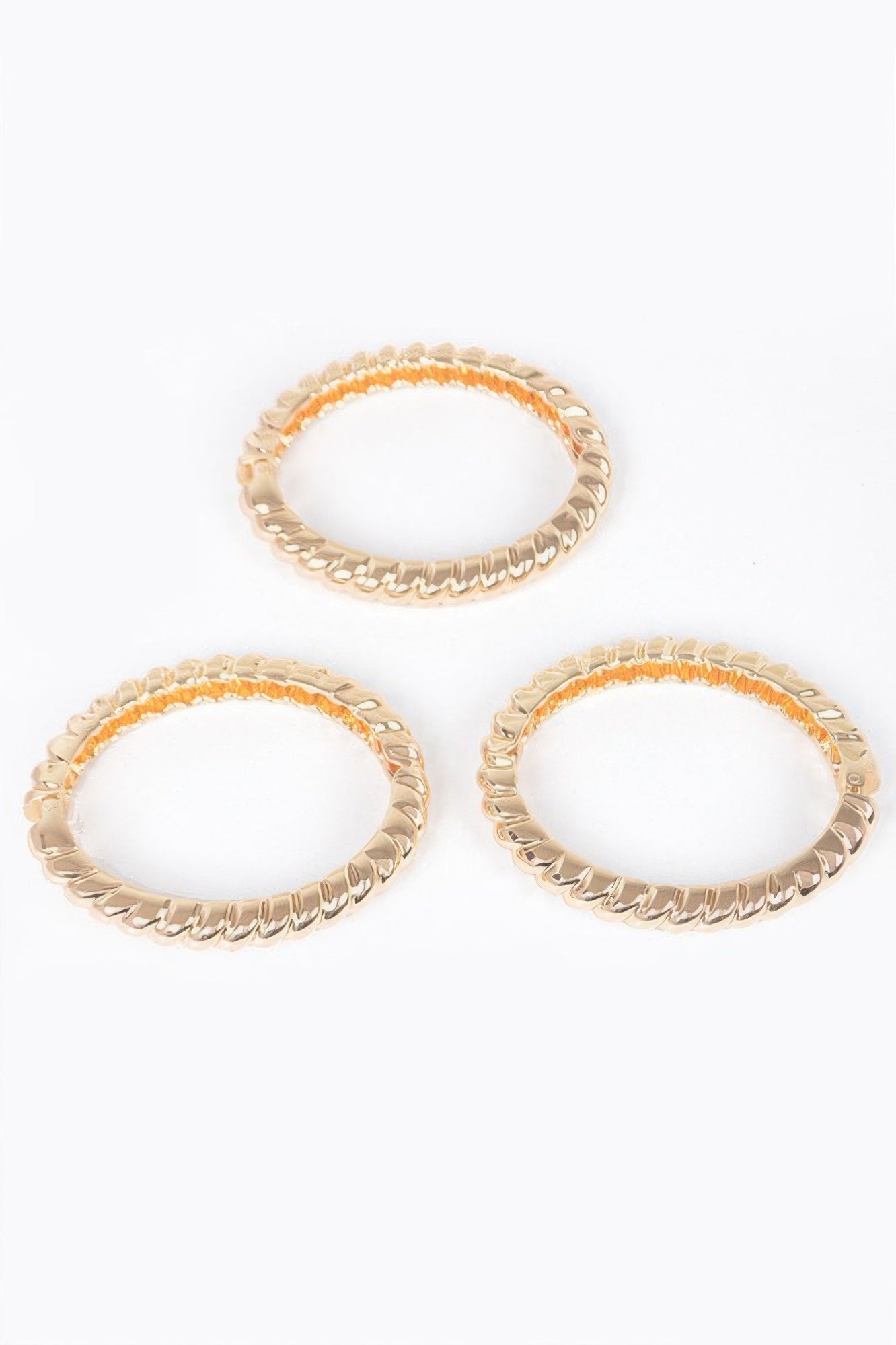 Three-piece metal bangle set, gold-tone bangles with orange-accent insets