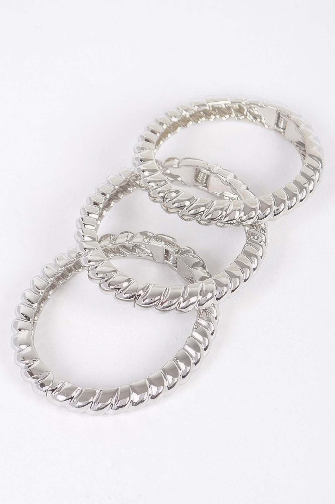 Three-piece metal bangle set, silver-tone linked bangles stacked in a side view