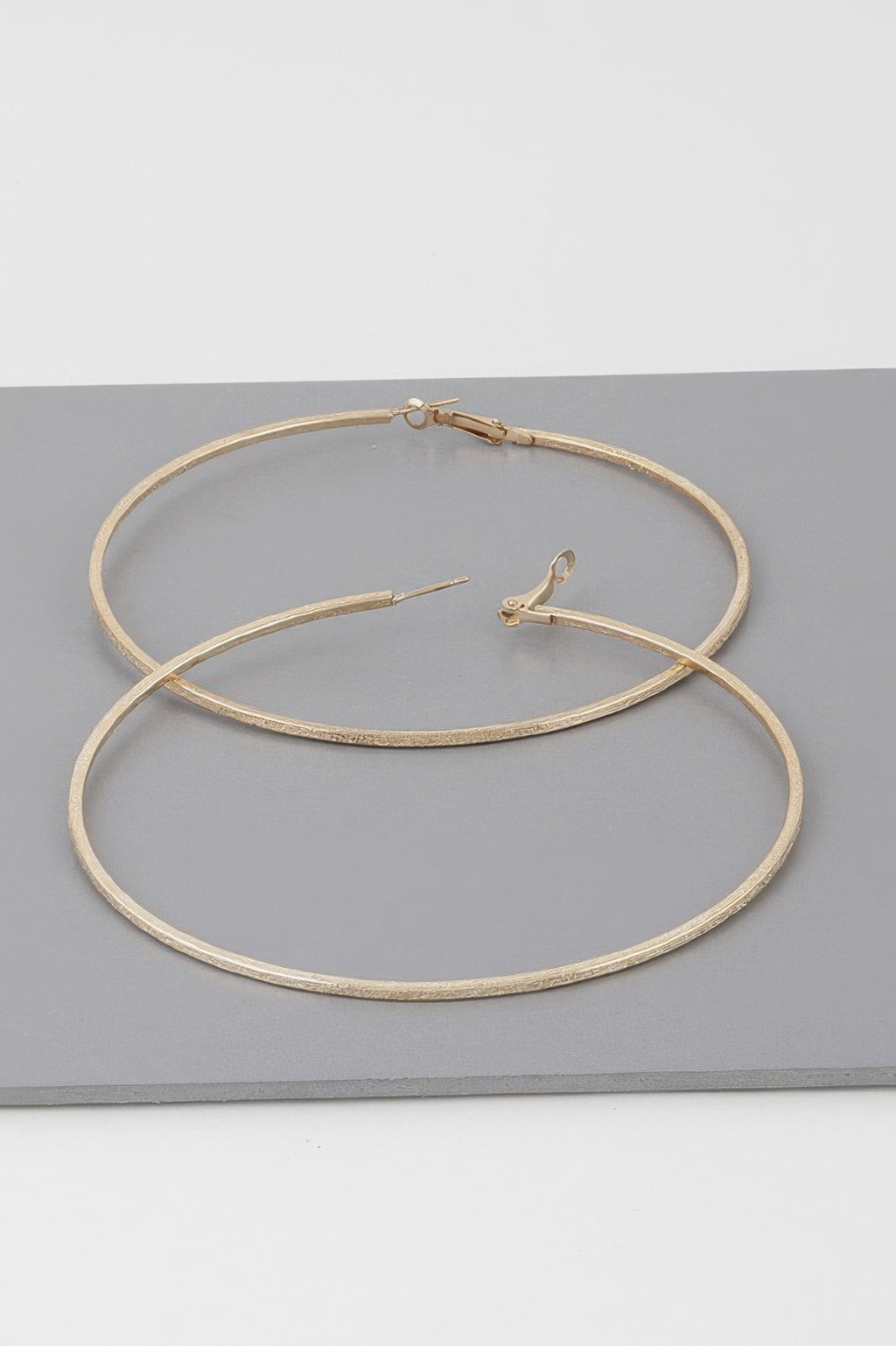 Wide indented hoop earrings, gold tone; two stacked hoops with hinge clasp