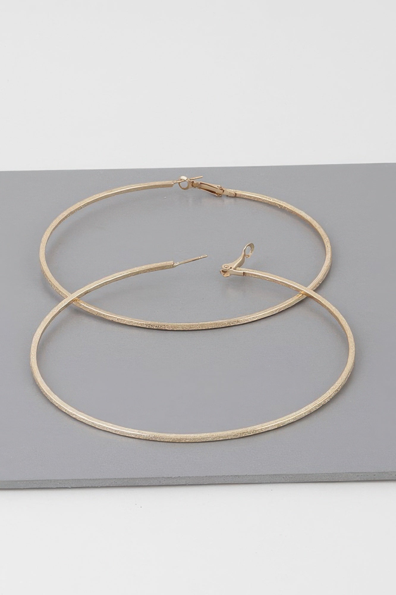 Wide indented hoop earrings, gold tone; two stacked hoops with hinge clasp